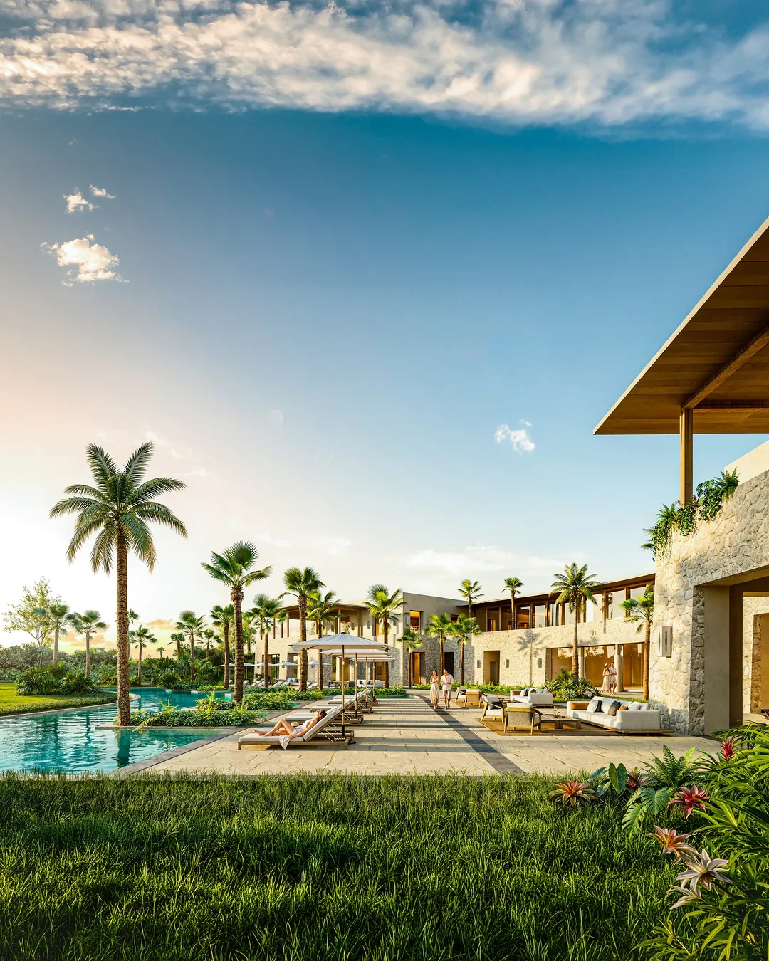 Clubhouse pool terrace at sunset, with loungers, palm trees and stone walls
