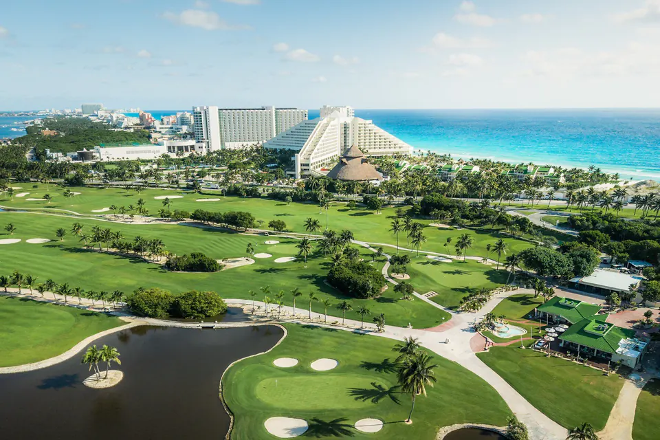 Aerial view of Iberostar Cancún Golf Club in Cancún's Hotel Zone, with hotels and the Caribbean Sea beyond