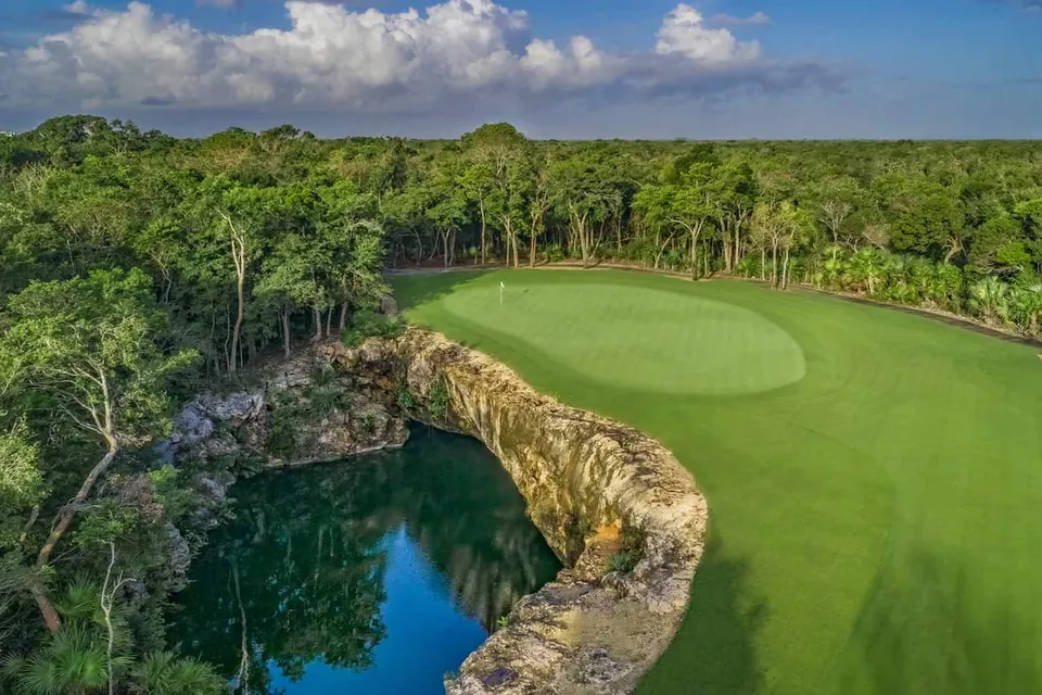 The 6th green at PGA Riviera Maya beside a cenote, surrounded by jungle
